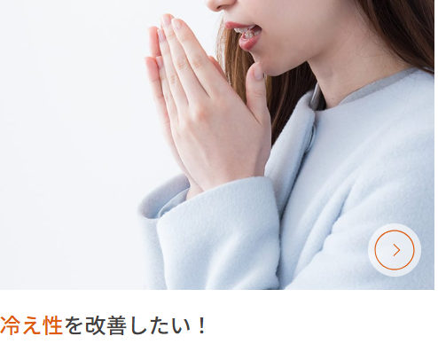 ALT="女性が冷たくなった手を息を吹きかけ温めている”